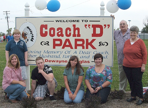 Coach D's Family in front of the Coach D Park sign